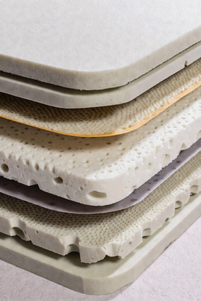Stacked eco-friendly latex and foam mattress layers showing natural materials