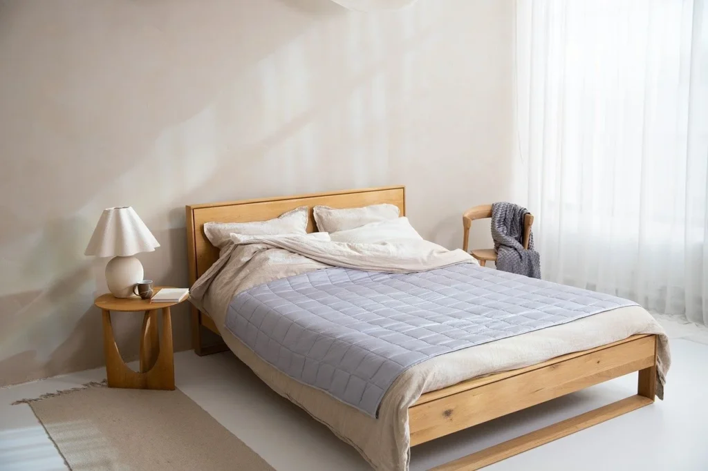 Wooden bed frame in a plain bedroom, ready to test how to fix a squeaky bed