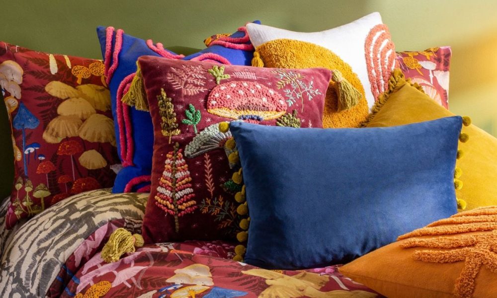 Maximalist bedding in boho colors with cozy pillows and morning light.